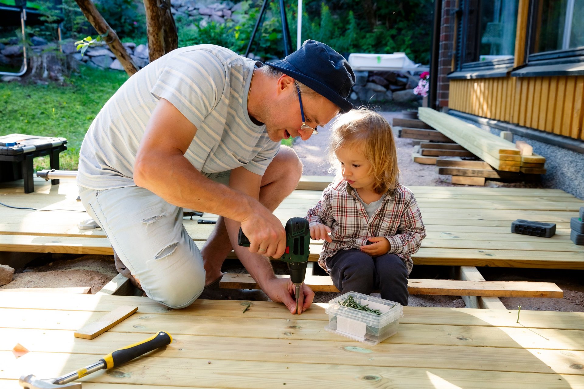 Father and daughter building a wooden patio deck together