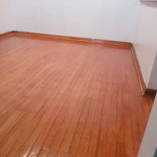 Empty room with brown laminate wood flooring and white walls